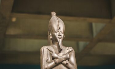 A detailed image of an ancient Egyptian statue displayed in a museum exhibit.