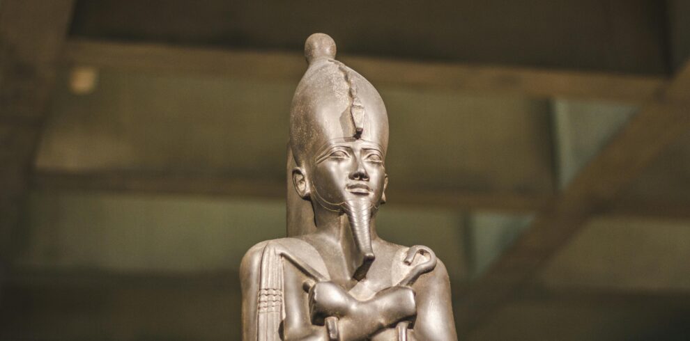 A detailed image of an ancient Egyptian statue displayed in a museum exhibit.
