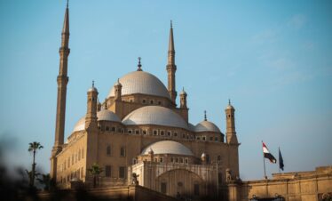 Explore the architectural beauty of the historic mosque in Cairo, featuring majestic domes and minarets.