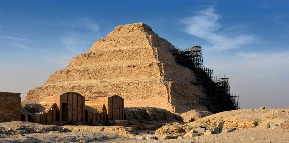 Step Pyramid of Djoser in Saqqara under restoration with clear blue sky.